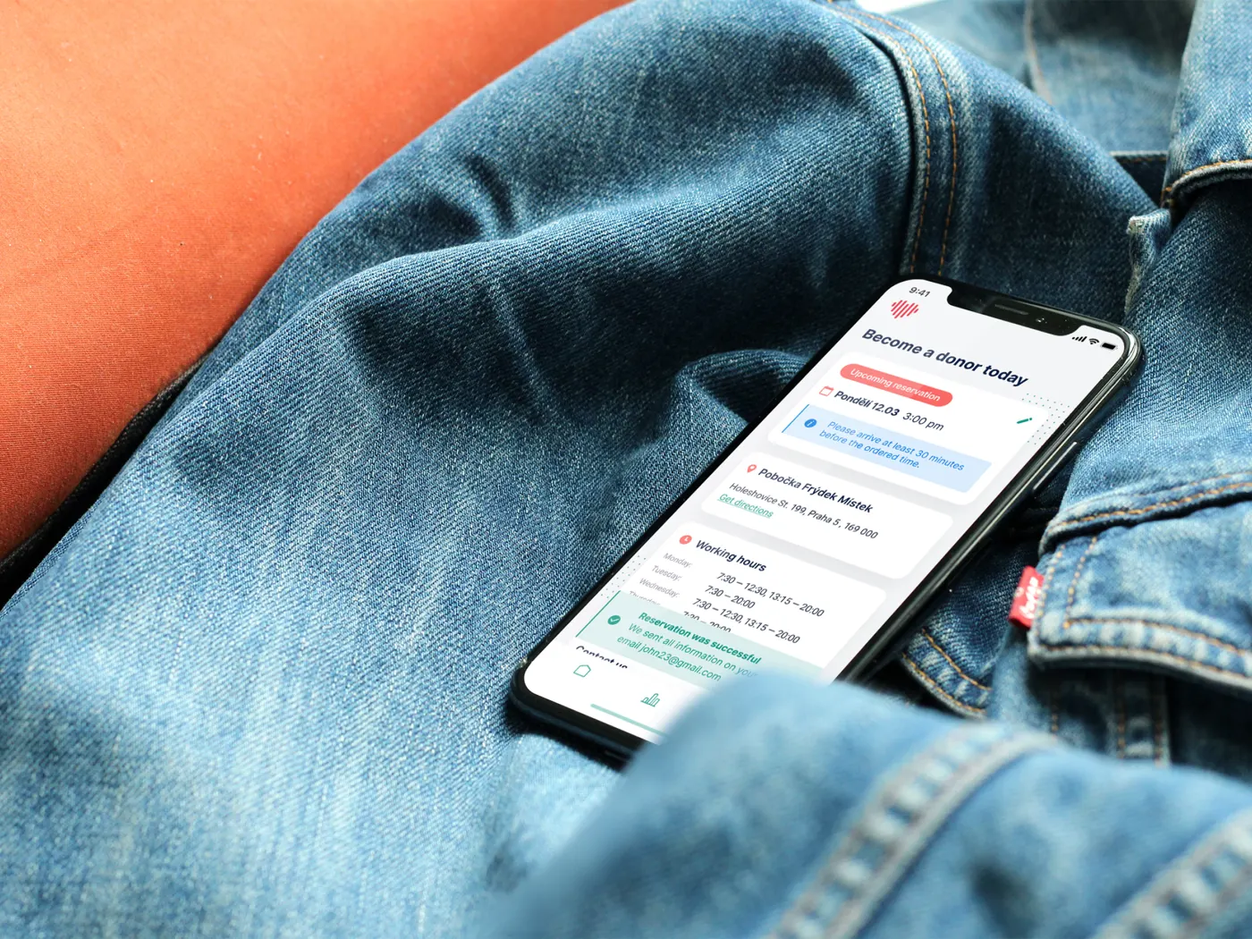 The plasma donor app on a phone resting on a denim jacket.